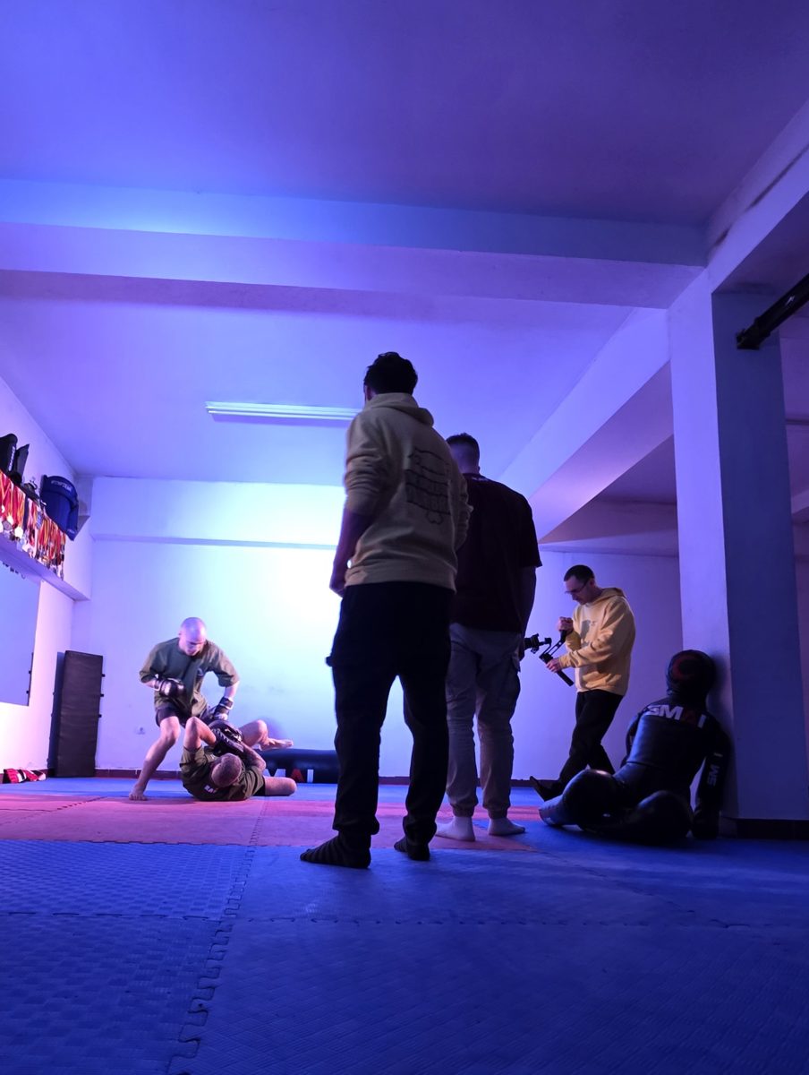 Crew filming a martial arts session under blue stage light